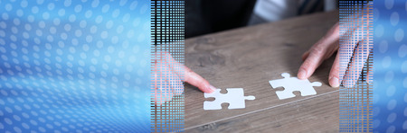Hands joining two puzzle pieces, teamwork concept. panoramic banner