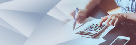 Female accountant using calculator in office. panoramic bannerの写真素材