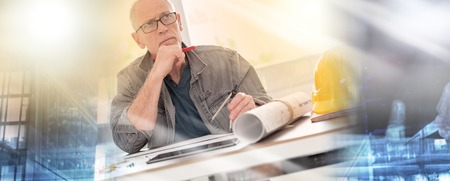 Architect working on plans at office, light effect; multiple exposureの写真素材