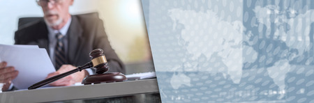 Judge gavel with lawyer working on legal document in background. panoramic banner