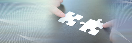 Hands joining two puzzle pieces, teamwork concept. panoramic banner