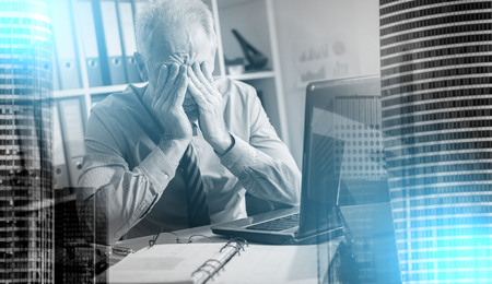 Tired businessman with headache in office, light effect; multiple exposureの写真素材