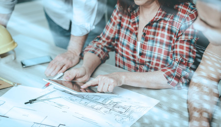 Architects working on plans at office, light effect