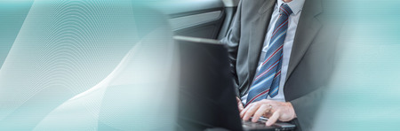 Businessman using his laptop while traveling. panoramic bannerの写真素材