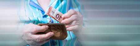 Old woman taking out a banknote from her wallet. panoramic banner