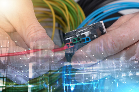Hand putting a wire in an electrical outlet; multiple exposure
