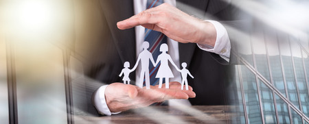 Concept of family insurance with hands protecting a family; multiple exposureの写真素材