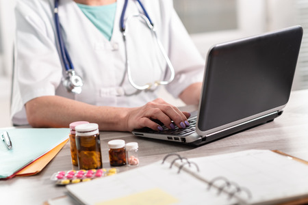 Female doctor using laptop in medical officeの写真素材