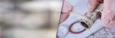 Plumber putting hemp fibers on a thread, closeup; panoramic banner