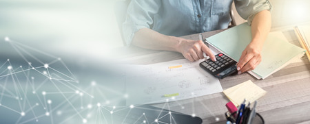 Female accountant using calculator in office; multiple exposure