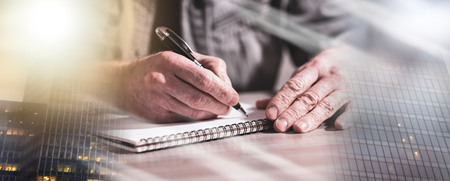 Male hands taking notes on a notebook. multiple exposureの写真素材