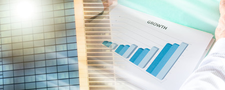 Businessman analyzing a graph showing growth; multiple exposureの写真素材