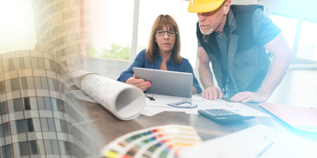 Architects working on plans at office; multiple exposureの写真素材