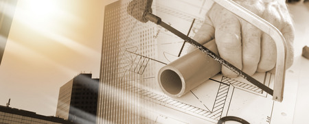 Plumber sawing a pvc pipe on a plan; multiple exposureの写真素材