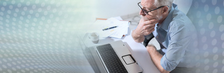Pensive senior businessman with hand on chin in office. panoramic bannerの写真素材