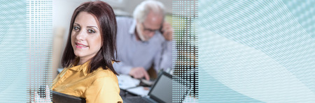 Portrait of young businesswoman sitting at desk in office, light effect; panoramic banner