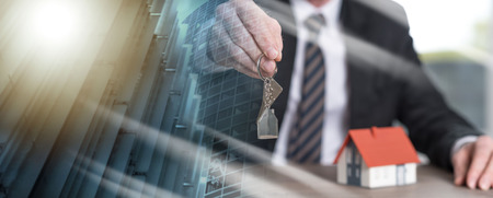 Real estate agent holding house keys, concept of home ownership. multiple exposure