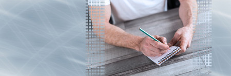Man taking notes on a pocket book; panoramic banner