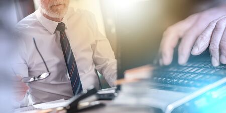Senior businessman holding his glasses, sitting in office. multiple exposure