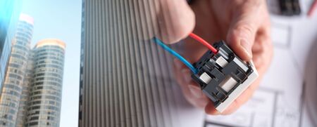 Electrician hands connecting a wire into a power socket; multiple exposure