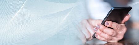 Close up of woman's hands using a mobile phone; panoramic bannerの写真素材
