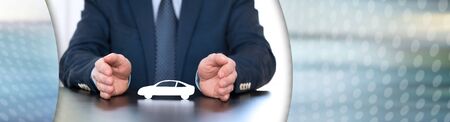 Insurer protecting a car with his hands; panoramic bannerの写真素材