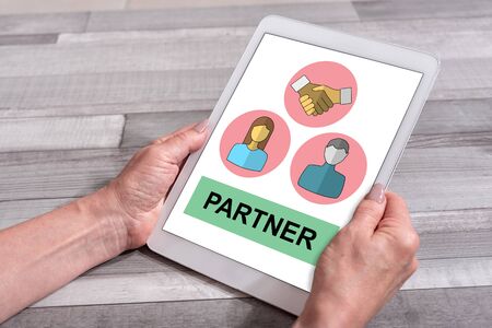 Female hands holding a tablet with partner conceptの写真素材