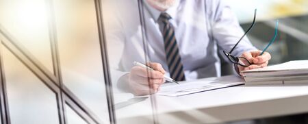Businessman checking a document in office; multiple exposureの写真素材