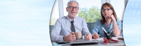 Portrait of two business people working together in office; panoramic bannerの写真素材