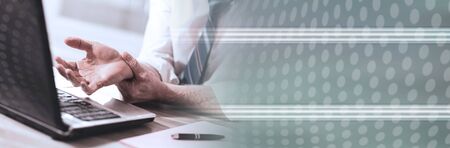 Businessman suffering from wrist pain at office; panoramic banner