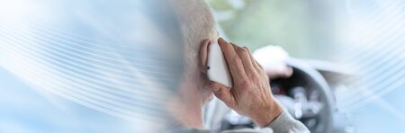 Man driving using smartphone; panoramic banner