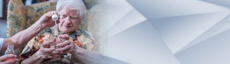 Medical assistant giving a drug to an old woman. panoramic bannerの写真素材
