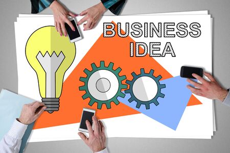 Business idea concept placed on a desk with hands using smartphonesの写真素材