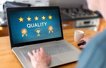 Man using a laptop with quality concept on the screenの写真素材