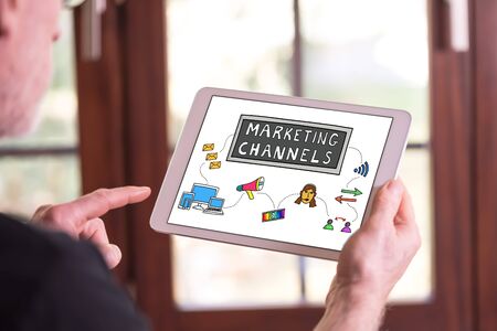 Man holding a tablet showing marketing channels conceptの写真素材
