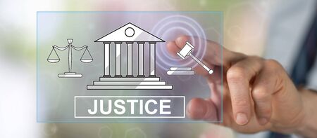 Man touching a justice concept on a touch screen with his fingerの写真素材