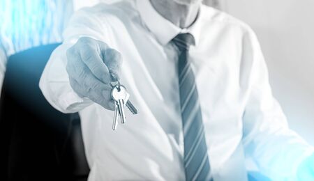 Real estate agent giving house keys, light effectの写真素材