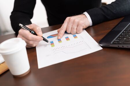 Businessman analysing marketing graphs at office
