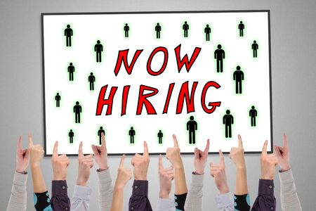 Hiring concept on a whiteboard pointed by several fingersの写真素材