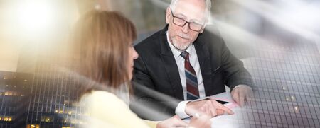 Financial consultant giving advices to female client, light effect; multiple exposure