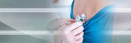 Doctor examining a patient with a stethoscope in his office; panoramic banner