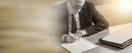 Businessman signing a document in office (lorem ipsum text used); light effectの写真素材