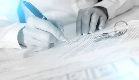 Client signing a real estate contract in real estate agency; light effect