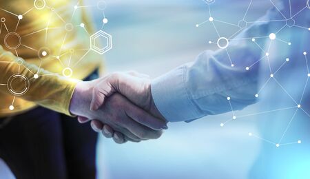 Businesswoman and businessman shaking hands in office; light effect