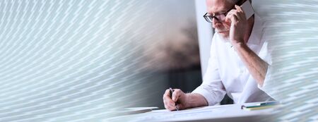 Bearded senior businessman talking on mobile phone in office, panoramic bannerの写真素材