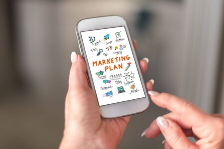 Marketing plan concept on a smartphone held by a handの写真素材