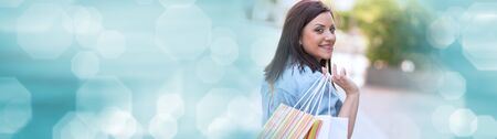 Pretty young woman walking with shopping bags in hand, panoramic bannerの写真素材