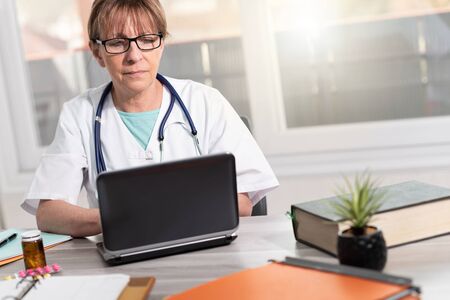 Female doctor using laptop in medical officeの写真素材