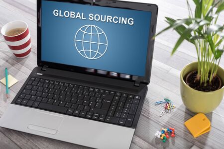 Laptop on a desk with global sourcing concept on the screenの写真素材