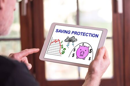 Man holding a tablet showing saving protection conceptの写真素材